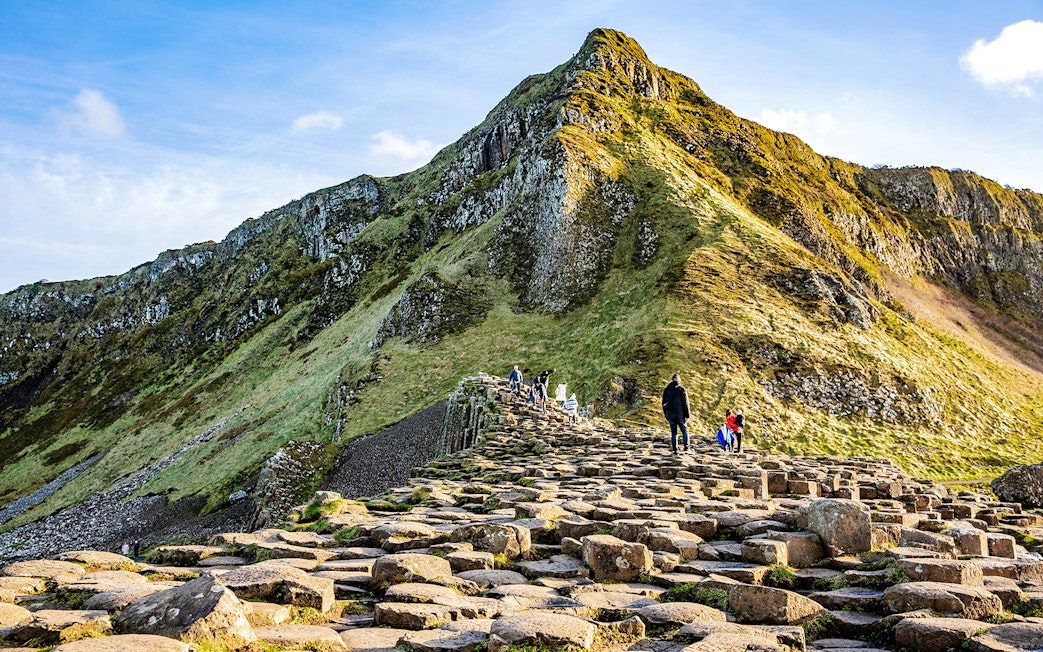 Visitors walking on basalt columns at Giant's Causeway, Northern Ireland.