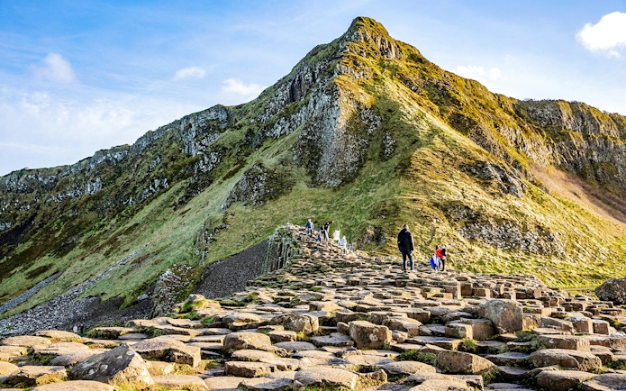 Visitors walking on basalt columns at Giant's Causeway, Northern Ireland.