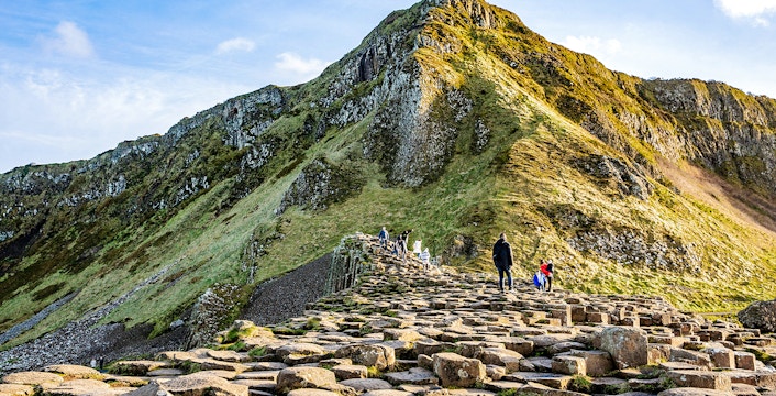 Visitors walking on basalt columns at Giant's Causeway, Northern Ireland.