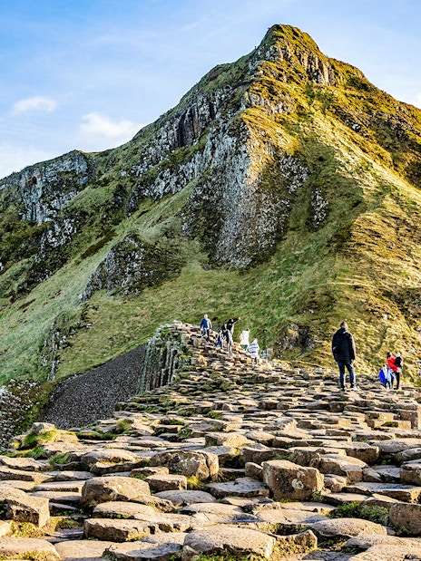Visitors walking on basalt columns at Giant's Causeway, Northern Ireland.