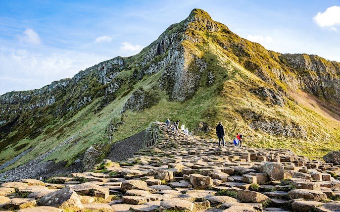 Visitors walking on basalt columns at Giant's Causeway, Northern Ireland.