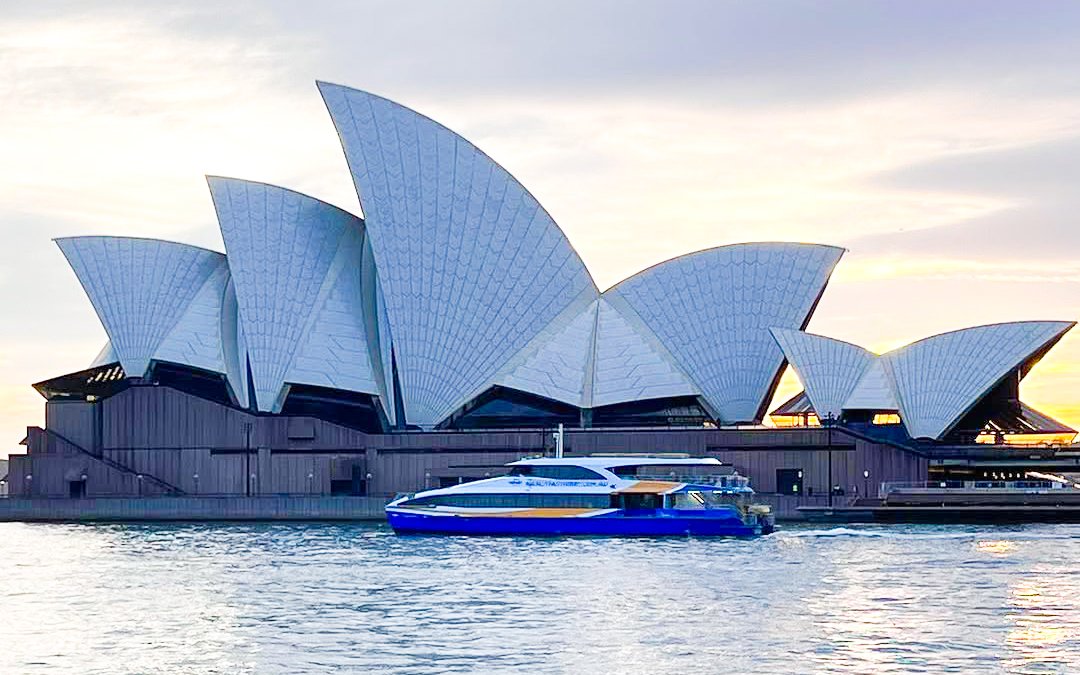 Comedy cruise near Sydney Opera House at sunset during Sydney Comedy Festival.