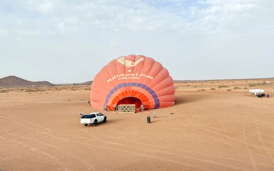 Crew inflating hot air balloon in Marrakech desert.