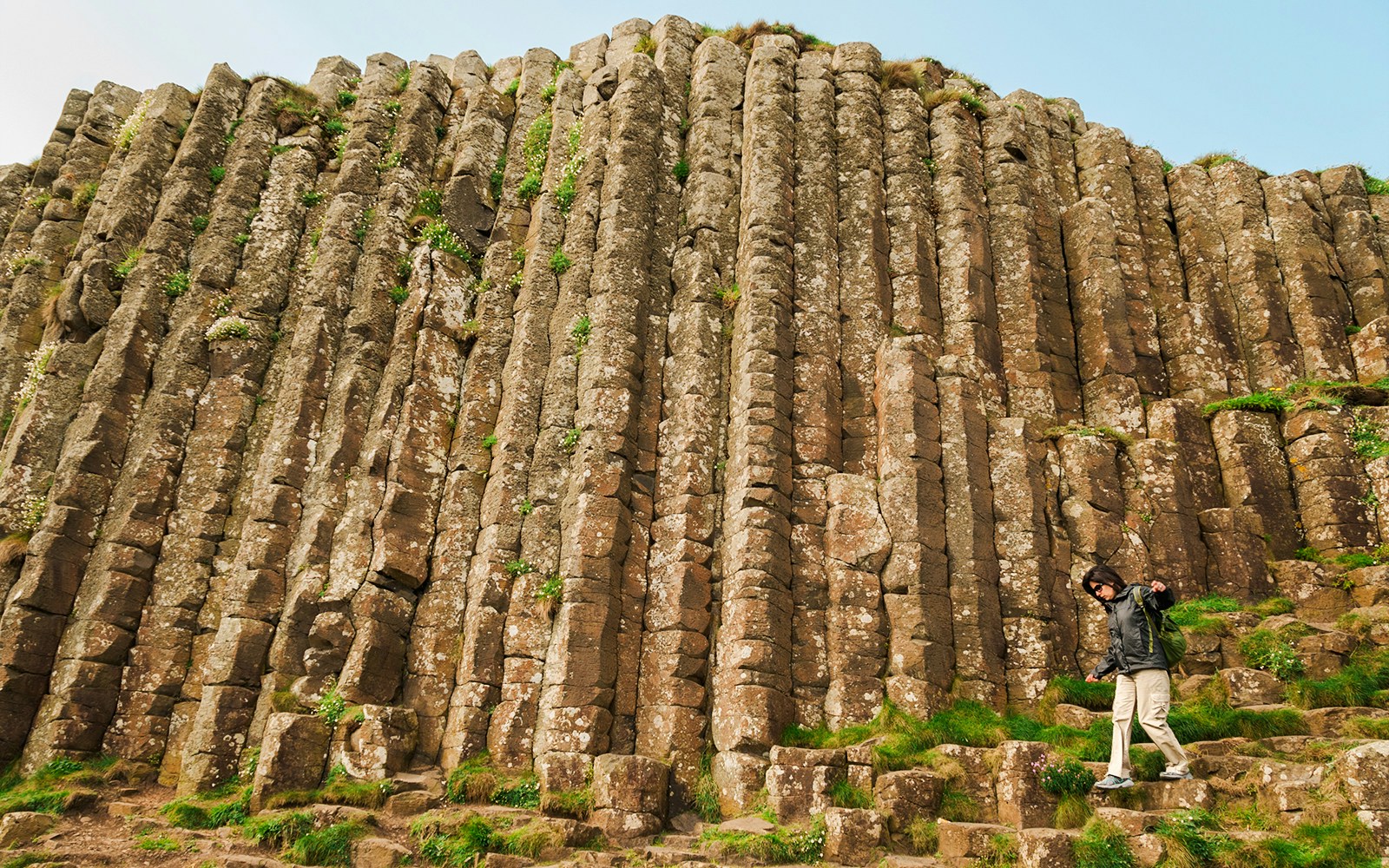Woman exploring hexagonal stones at Giant's Causeway, Northern Ireland.