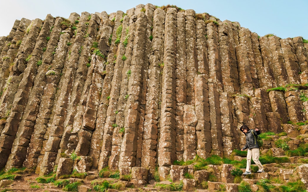 Woman exploring hexagonal stones at Giant's Causeway, Northern Ireland.