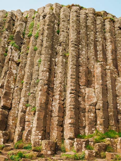 Woman exploring hexagonal stones at Giant's Causeway, Northern Ireland.