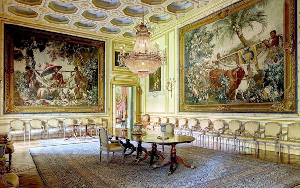 Liria Palace interior with ornate tapestries and chandelier in a grand room.