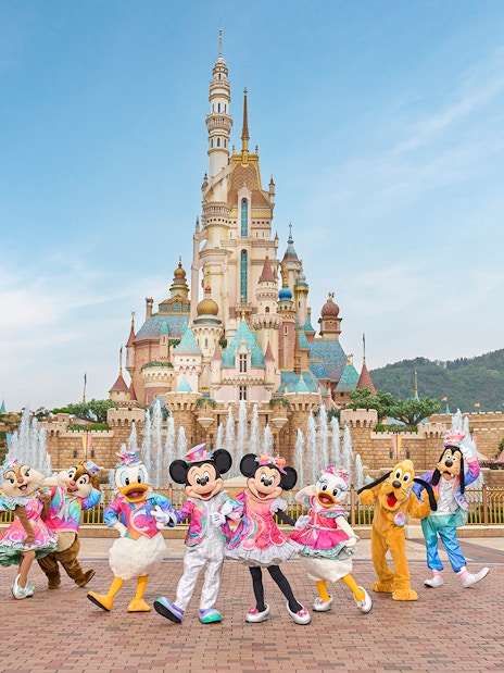 Disney characters celebrating 20th anniversary at Hong Kong Disneyland castle.
