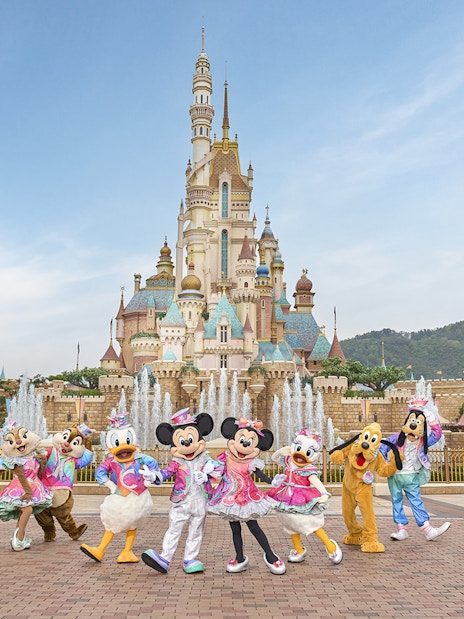 Disney characters celebrating 20th anniversary at Hong Kong Disneyland castle.
