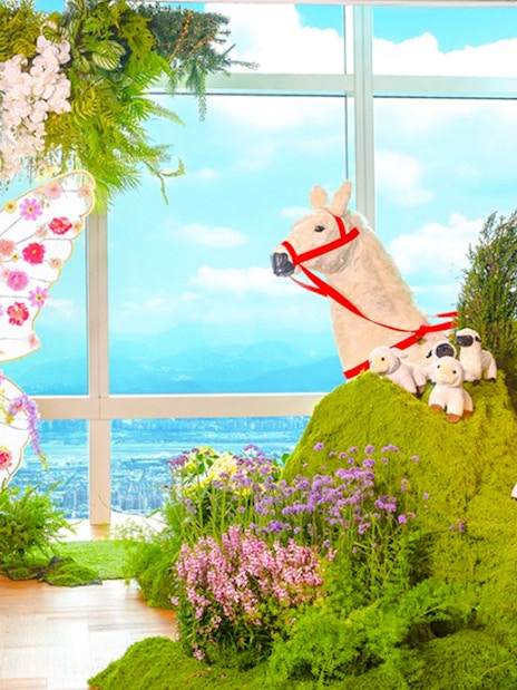 Colorful butterfly display and animal figures with Taipei 101 view in background.