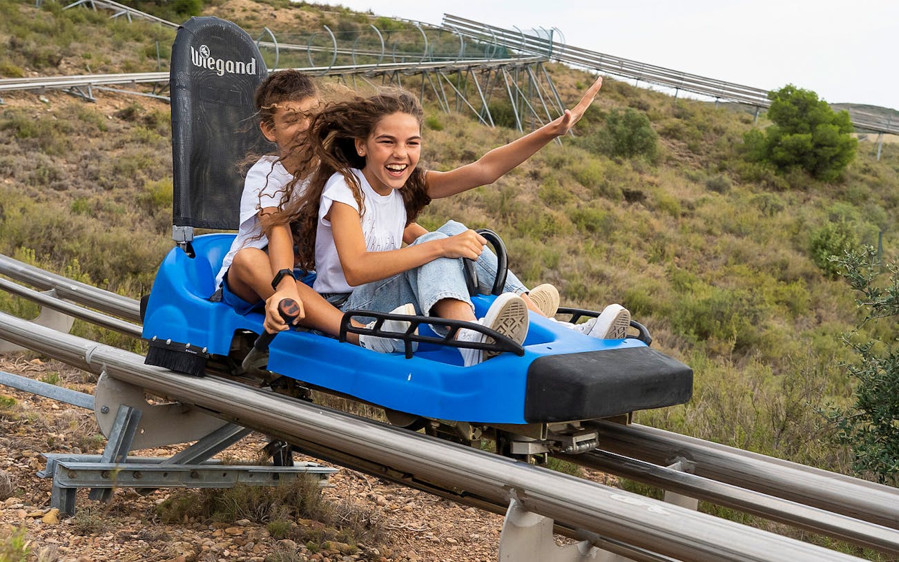 Children enjoying a roller coaster ride at Sendaviva Natural Park.