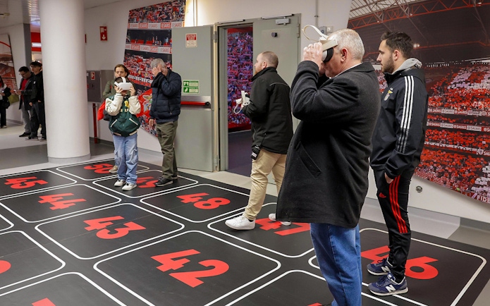 Visitors using VR headsets in Benfica Stadium's virtual reality room.