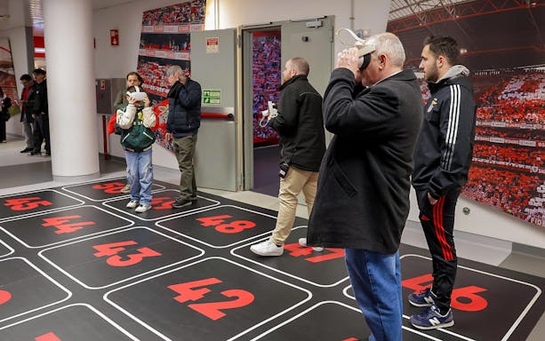 Visitors using VR headsets in Benfica Stadium's virtual reality room.