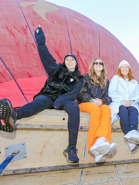 Group preparing for balloon flight at Teotihuacán with colorful balloons in the background.