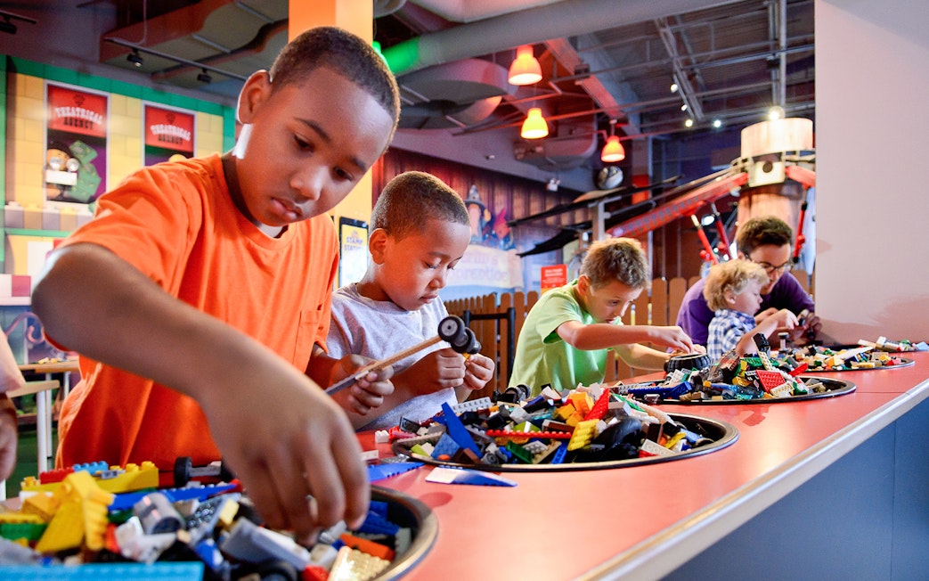 Children building with LEGO bricks at a Chicago attraction.