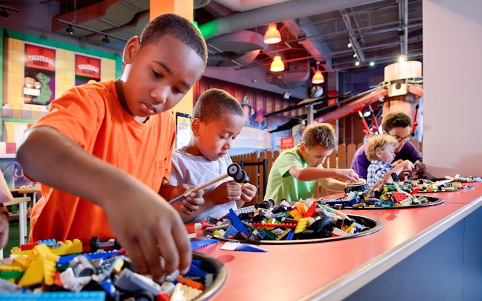Children building with LEGO bricks at a Chicago attraction.