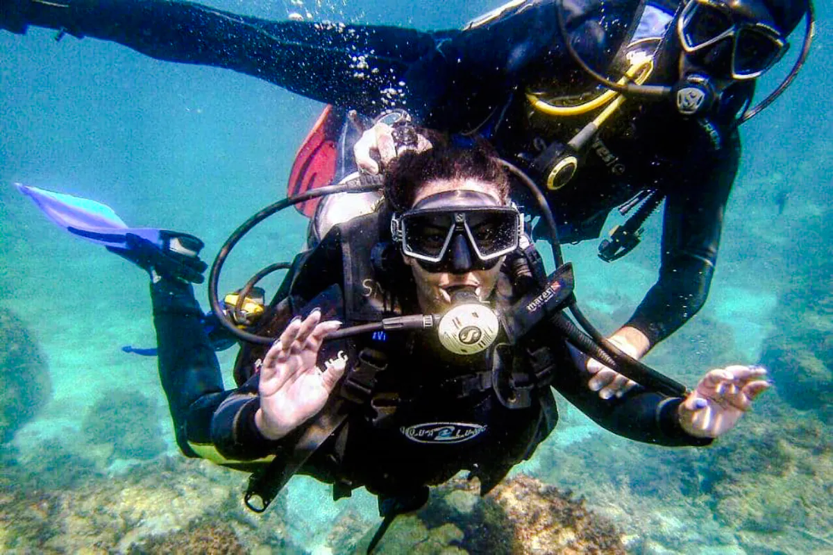 Scuba divers exploring underwater in Angra, Rio de Janeiro.