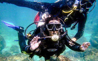 Scuba divers exploring underwater in Angra, Rio de Janeiro.