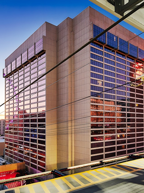 Fly LINQ Zipline view with High Roller Ferris wheel, Las Vegas skyline at sunset.