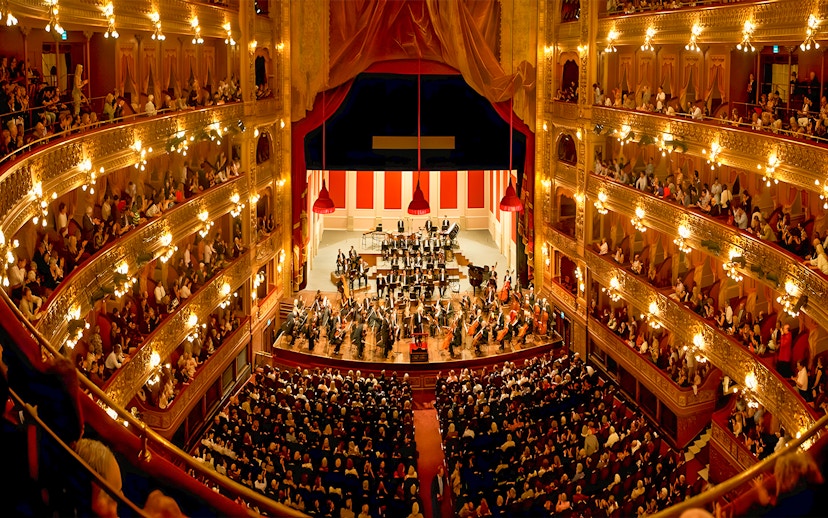 Teatro Colon interior with audience and orchestra on stage.