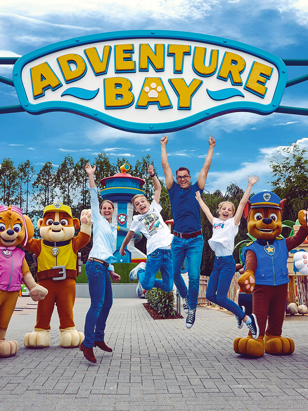 Visitors jumping with joy at Adventure Bay entrance in Movie Park, surrounded by character mascots.