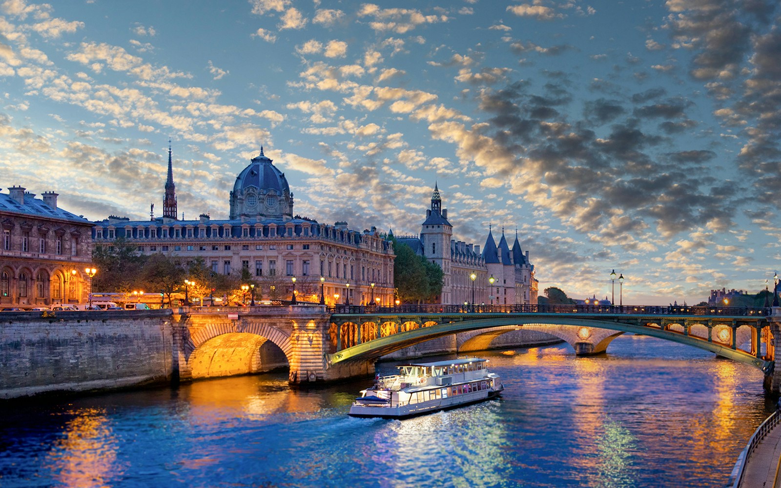 Conciergerie Museum at sunset viewed from a Seine River dinner cruise with live music.