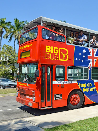 Red double-decker bus with tourists on a hop-on hop-off tour in Darwin, Australia.