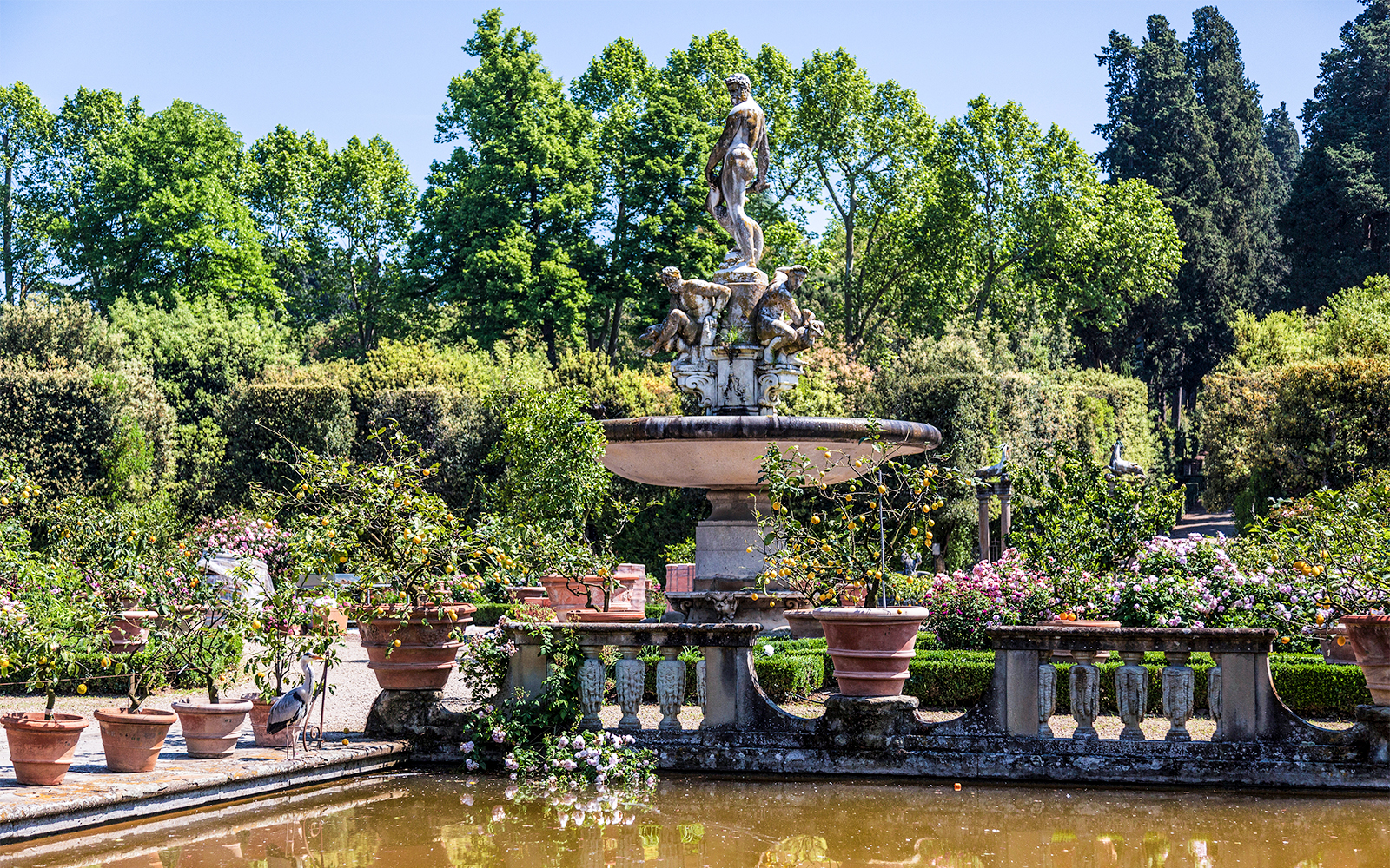 Fountain with statues surrounded by greenery in Boboli Gardens, Florence.