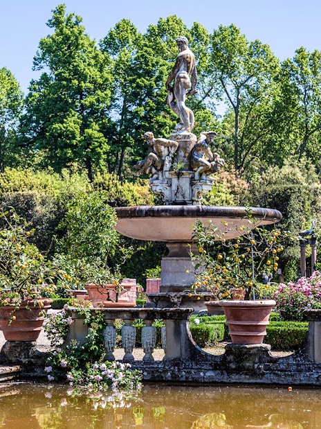 Fountain with statues surrounded by greenery in Boboli Gardens, Florence.