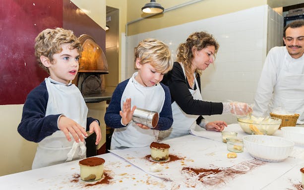 Kids making tiramisu in a Rome cooking class kitchen.