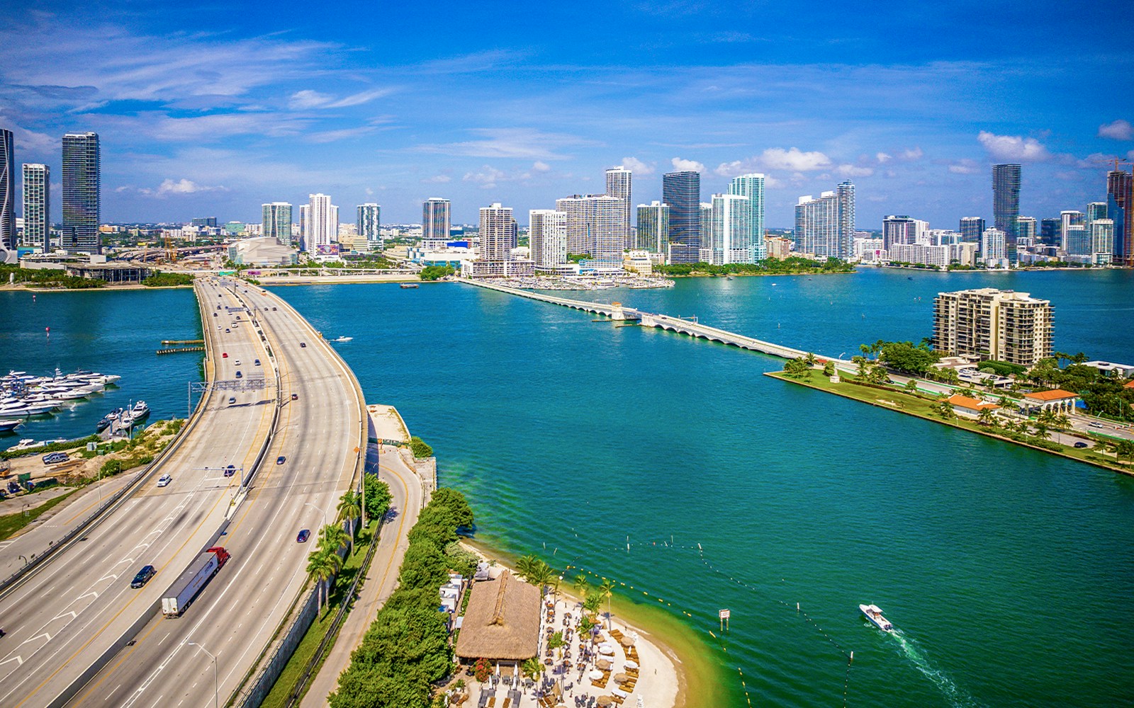 Speedboat cruising through Biscayne Bay, Miami with city skyline in the background.