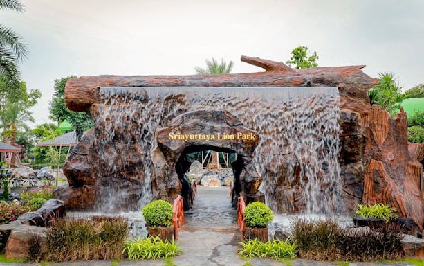 Entrance of Sri Ayutthaya Lion Park with waterfall feature and greenery.