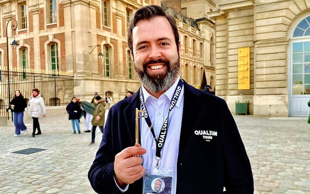 Tour guide holding a key outside the Palace of Versailles.