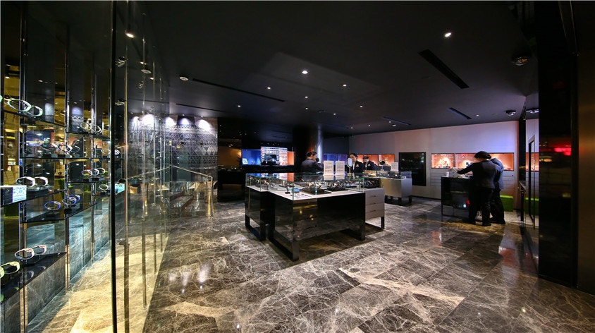 Watch store interior at Oriental Pearl Tower, Shanghai, with display cases and customers browsing.