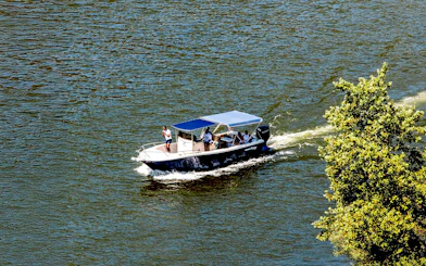 Boat cruising on Douro River in the evening with passengers enjoying the view.