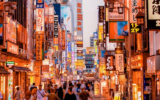 Bustling street in Tokyo, Japan, with vibrant neon signs and crowds, ideal for 3G Tourist eSIM use.