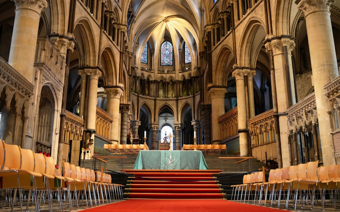Presbytery and High Altar inside Canterbury Cathedral with stained glass windows.