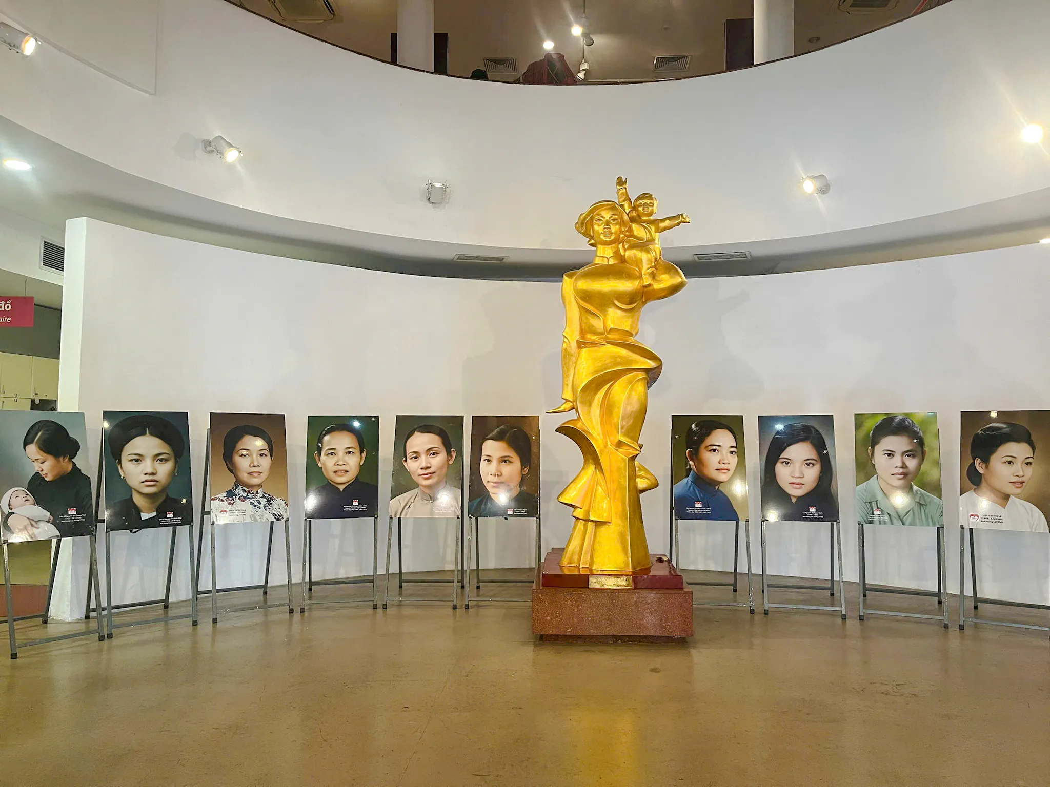 Golden statue and portraits at Vietnamese Women Museum, Hanoi, part of the Hoa Lo Prison Walking Tour.