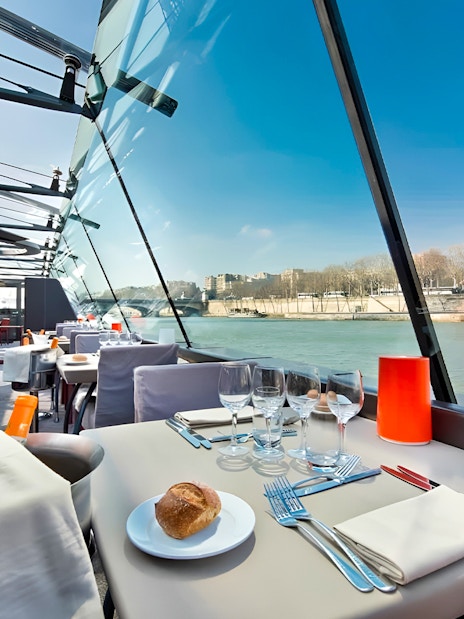 Bateaux Parisiens lunch cruise table setting with Seine River view in Paris.