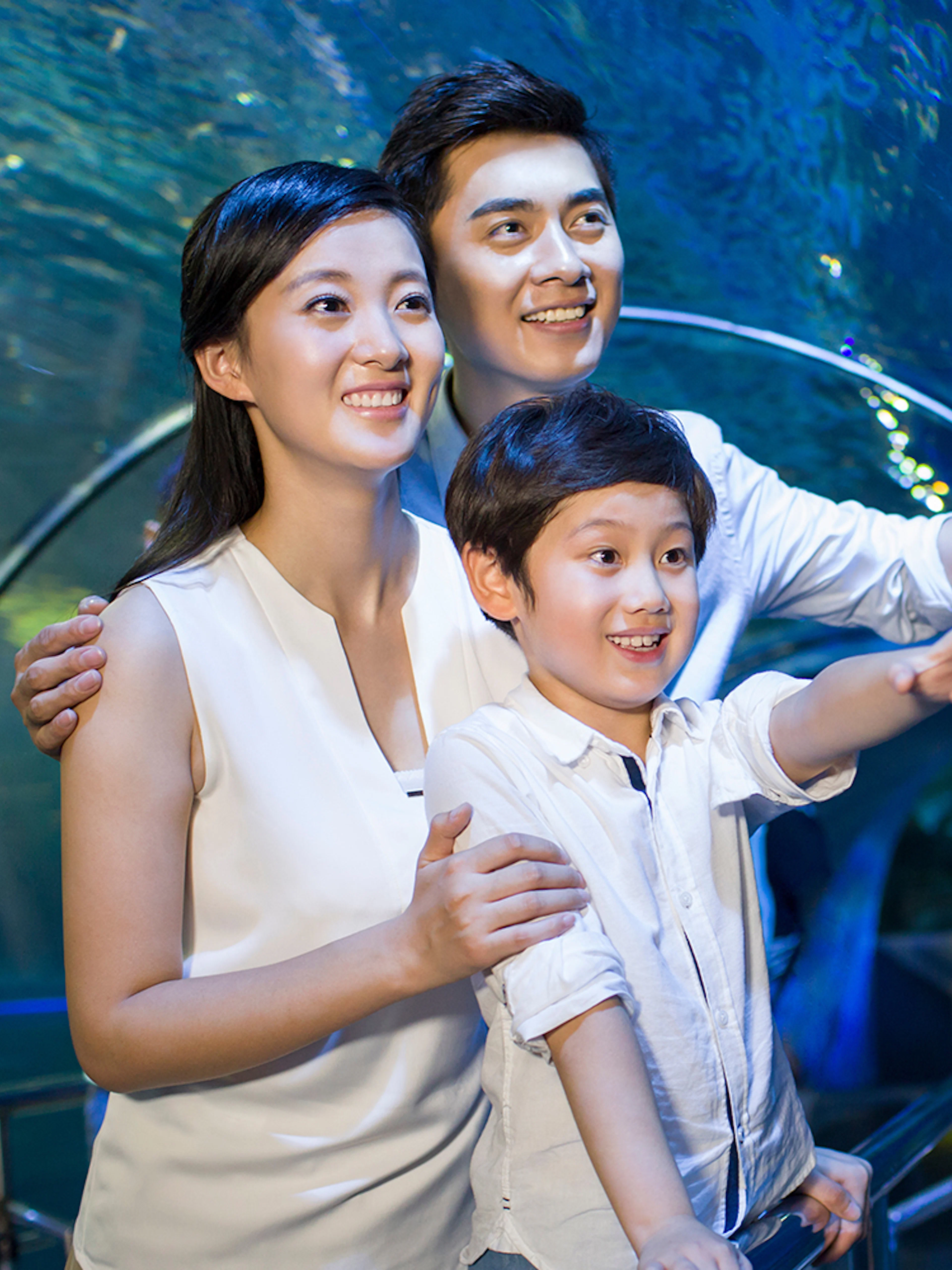 Family enjoying an underwater tunnel at an aquarium.