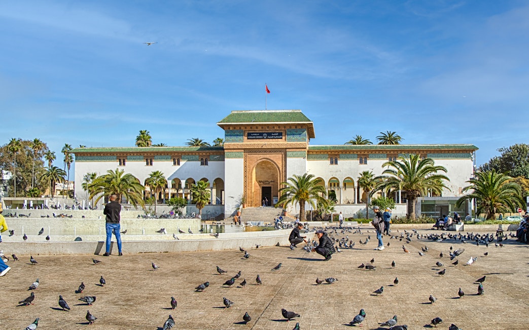 Palace of Justice on Mohammed V Square, Casablanca, with people and pigeons in the foreground.