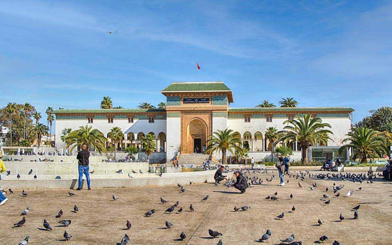 Palace of Justice on Mohammed V Square, Casablanca, with people and pigeons in the foreground.