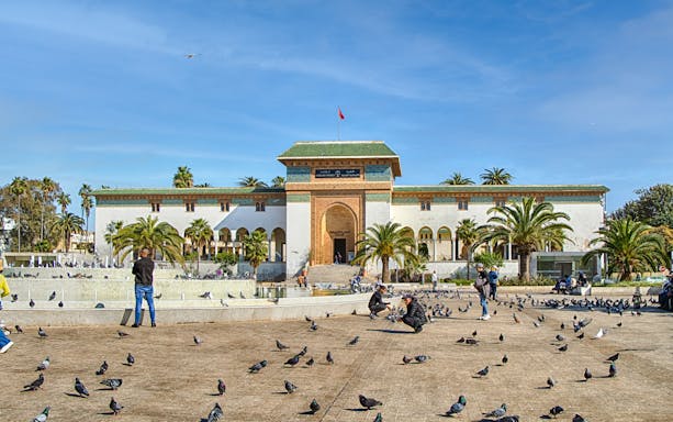 Palace of Justice on Mohammed V Square, Casablanca, with people and pigeons in the foreground.