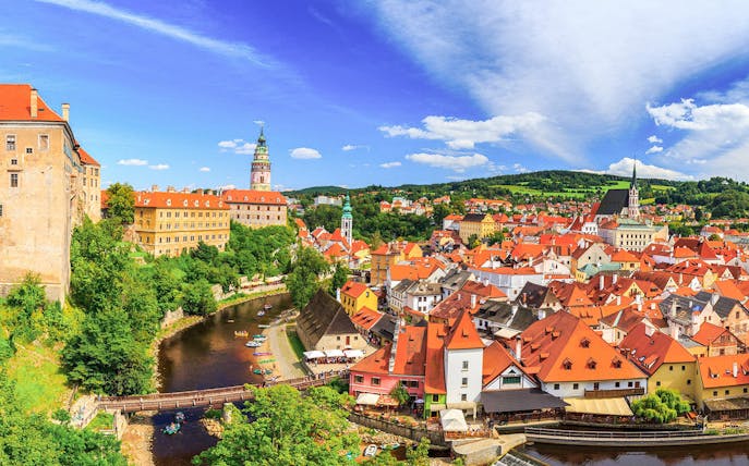 Aerial view of Cesky Krumlov with castle, river, and red-roofed buildings.