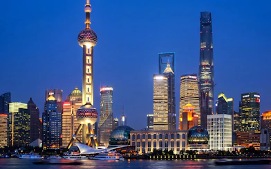 Oriental Pearl Tower illuminated at night in Pudong, Shanghai, viewed from across the Huangpu River.