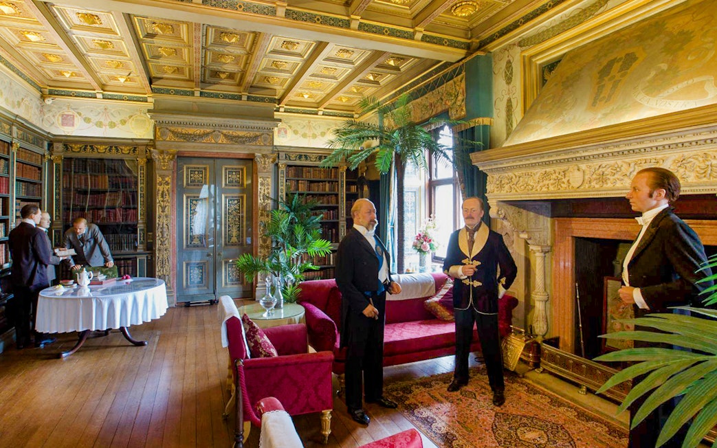 Warwick Castle interior with wax figures in period attire, showcasing historical decor.