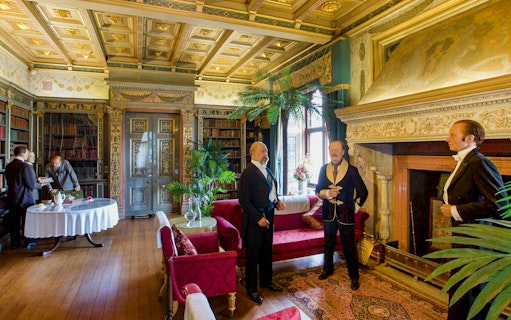 Warwick Castle interior with wax figures in period attire, showcasing historical decor.