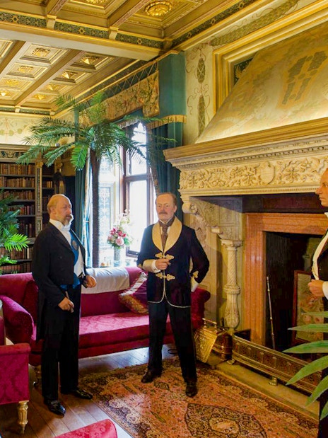 Warwick Castle interior with wax figures in period attire, showcasing historical decor.