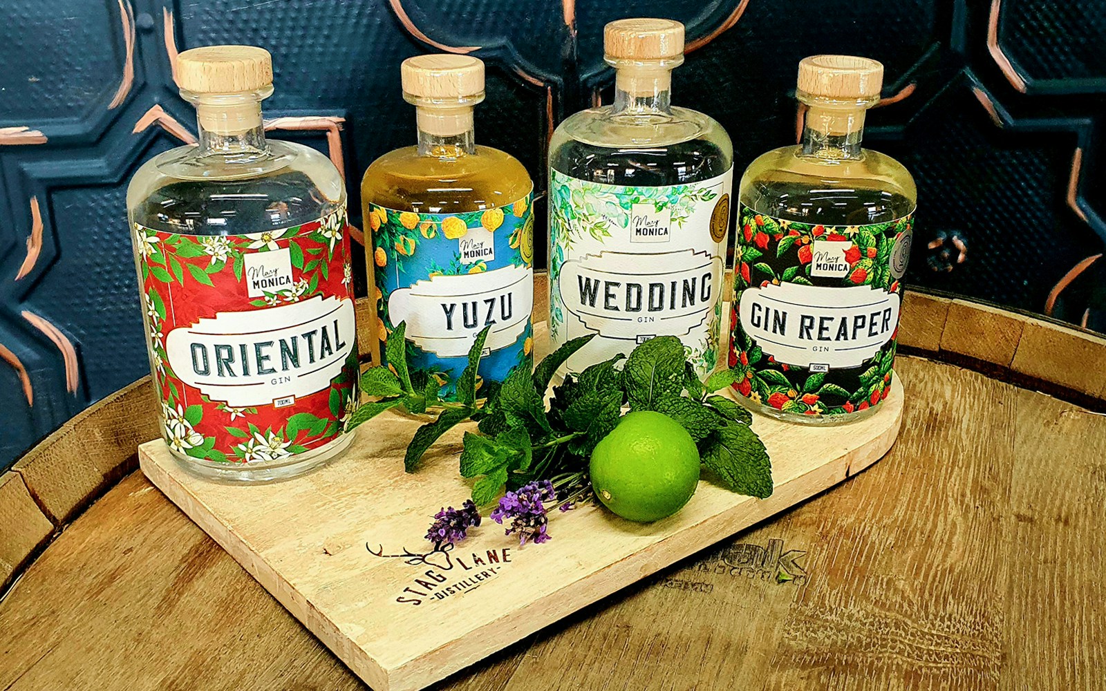 Bottles of Oriental, Yuzu, Wedding, and Gin Reaper gin on a wooden tray with mint and lime, Yarra Valley.