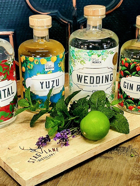 Bottles of Oriental, Yuzu, Wedding, and Gin Reaper gin on a wooden tray with mint and lime, Yarra Valley.